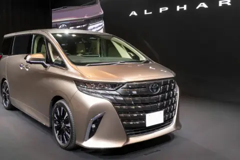 Elegancki, brązowy Toyota Alphard prezentuje się na czarnym tle.