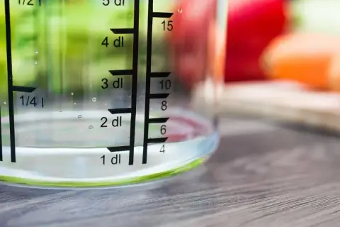 Miarka pokazuje, ile szklanka ma mililitrów wody. Woda sięga do poziomu 1 dl, czyli 100 ml.