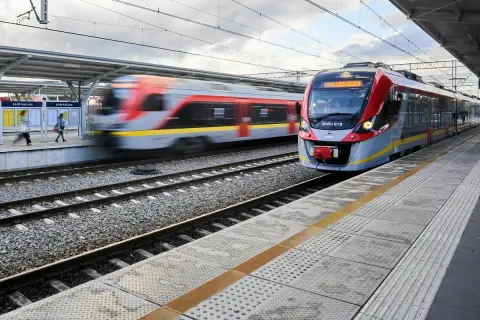 Nowoczesny pociąg PKP Intercity zbliża się do stacji Łódź Kaliska. W tle widać drugi pociąg w ruchu.