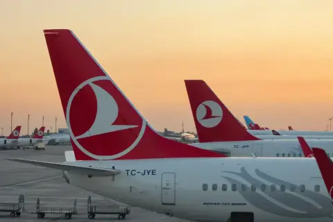 O zachodzie słońca samoloty Turkish Airlines czekają na pasażerów i ich bagaż.