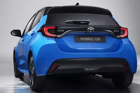 Niebieski hatchback Toyota Yaris IV z czarnym dachem i napisem HYBRID 130 z tyłu.