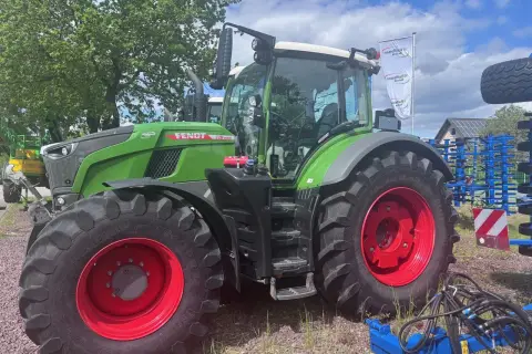 Zielony traktor Fendt 930 Vario z czerwonymi felgami, gotowy do pracy na polu.