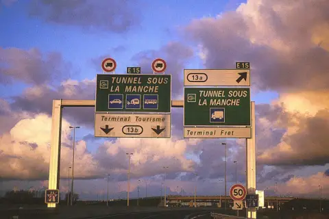 Znaki drogowe kierujące do "TUNNEL SOUS LA MANCHE" (Tunel pod kanałem La Manche) dla ruchu turystycznego i towarowego.