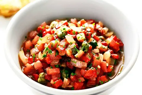 En skål med färsk salsa, perfekt för ditt salsa recept. Tomater, lök och örter blandas till en läcker röra.