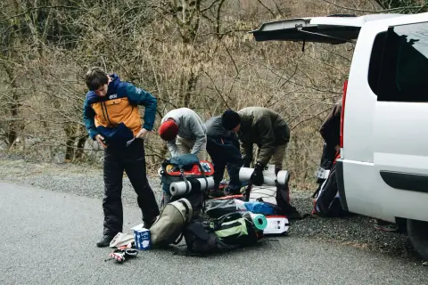 Grupa przygotowuje się do wyprawy w Tatry Wysokie, pakując sprzęt przy samochodzie.
