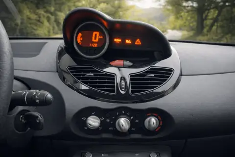 Tableau de bord d'une Twingo 2, prêt pour la vidange. Le compteur affiche 0 km/h, avec des voyants moteur et d'alerte allumés.