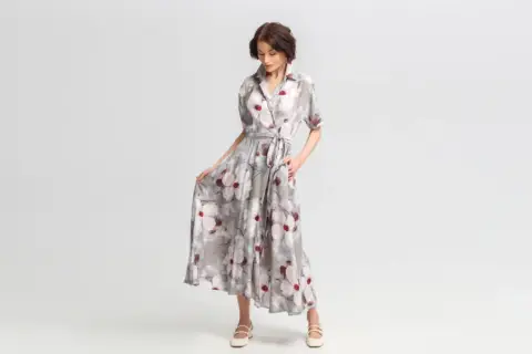 Elegancka stylizacja na wieczór: zwiewna sukienka maxi w kwiaty, z wiązaniem w talii i dekoltem koszulowym.