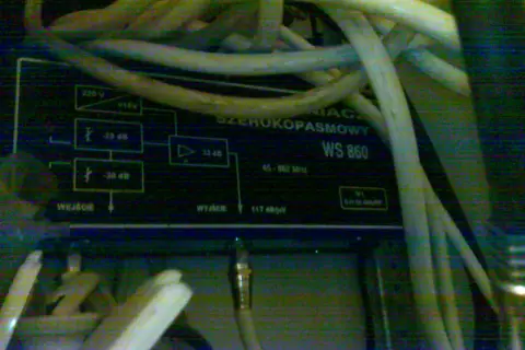 Wzmacniacz sygnału telewizji kablowej w bloku, model WS 860, z licznymi kablami.