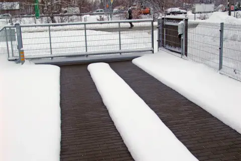 Śnieg pokrywa podjazd, ale dzięki systemowi podgrzewania, ścieżki dla samochodów pozostają czyste.