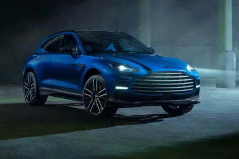 Niebieski Aston Martin DBX 707 lśni w półmroku, gotowy do podboju każdej drogi.
