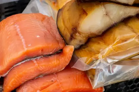 Świeży łosoś wędzony na zimno obok wędzonej makreli.