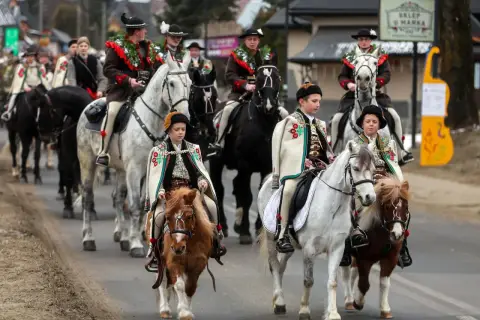 Dzieci i dorośli w strojach góralskich na koniach, jakby znali znane piosenki góralskie.