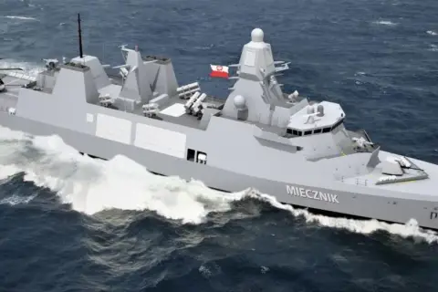 Nowoczesna fregata ORP Miecznik, część polskiej marynarki wojennej, z helikopterem na pokładzie, pruje fale.