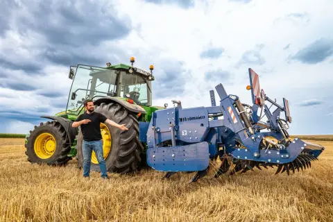Un homme présente une charrue Rolmako, un outil agricole essentiel pour préparer les sols. La sep charrue définition est ici illustrée par cet équipement robuste.