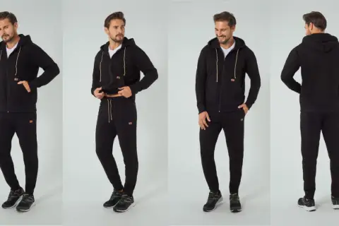 Mężczyzna prezentuje czarny dres sportowy męski z kapturem i zamkiem. Idealny na co dzień i trening.