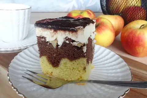 Pyszne ciasto Fale Dunaju z kremem i polewą czekoladową, obok jabłka i filiżanka kawy.