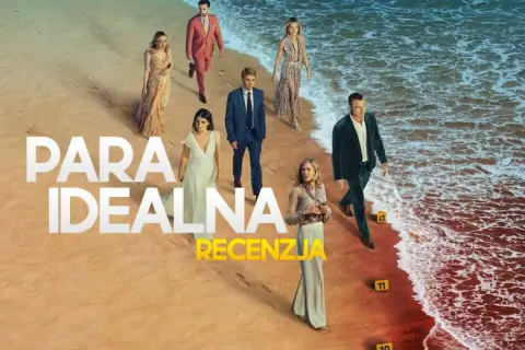 Grupa ludzi na plaży, w tym para idealna serialu. W tle morze i piasek.