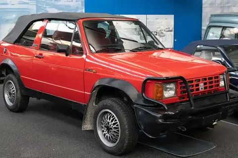 Roter Biagini Passo Cabriolet mit schwarzem Verdeck und auffälligem Kühlergrill-Schutz.