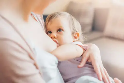 Bambina di 18 mesi allattata al seno, un momento intimo di nutrimento e amore.