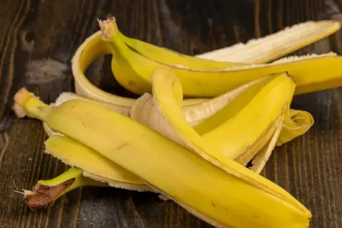 Skórki bananów na drewnianym blacie. Czy to wyjaśnia, dlaczego koty boją się bananów?