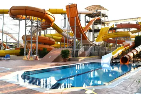 Wodny park rozrywki w Turcji, idealny na upalną pogodę w sierpniu. Kolorowe zjeżdżalnie i basen zapraszają do zabawy.
