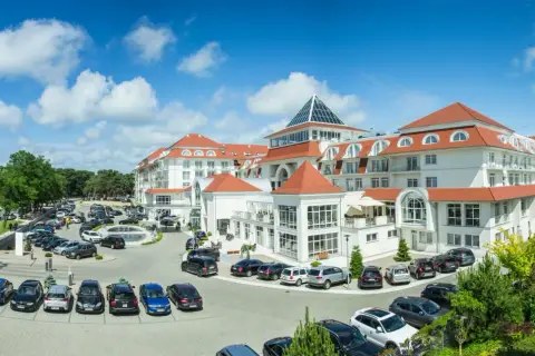 Elegancki hotel 5 gwiazdkowy nad morzem z dużym parkingiem i zielonym otoczeniem.