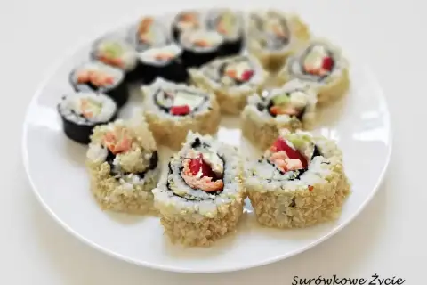 Talerz pełen pysznych roladek california sushi, z łososiem i awokado, posypanych sezamem.