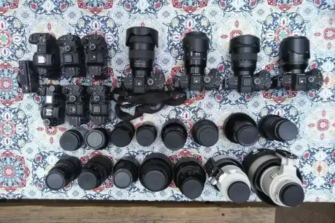 Kolekcja aparatów i obiektywów, w tym teleobiektyw. Zastanawiasz się, teleobiektyw co to? To obiektyw o długiej ogniskowej, idealny do fotografowania odległych obiektów.