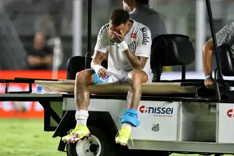 Neymar siedzi na wózku, zakrywając twarz dłońmi. Wygląda na to, że jego **neymar kontuzja** jest poważna.