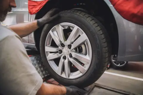 Mechanik sprawdza oponę, szukając oznak bicia opony objawy.