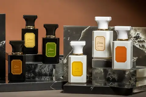 Elegantes frascos de perfume, algunos negros y otros blancos, con etiquetas doradas. Podrían ser la mejor colonia Mercadona hombre.