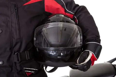 Motociclista con casco negro y chaqueta roja. Aprende como poner pinlock para evitar vaho.