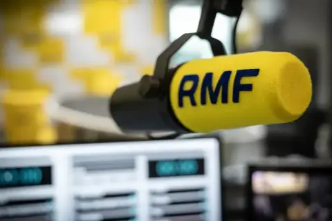 Mikrofon RMF z żółtym wiatrochronem w studiu radiowym. Słuchaj ulubionych stacje radiowe częstotliwości.
