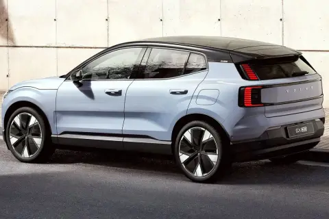 Nowy, elektryczny Volvo EX30 w kolorze jasnoniebieskim prezentuje się nowocześnie na tle betonowej ściany.
