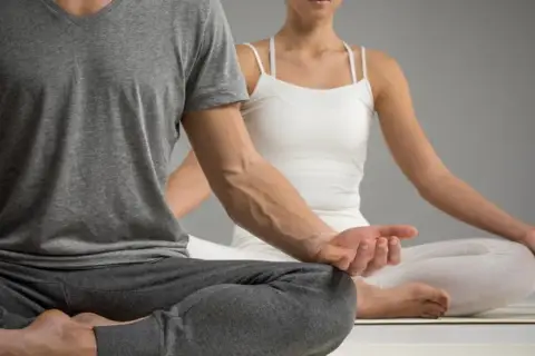 Para ćwiczy jogę kundalini w pozycji medytacyjnej.