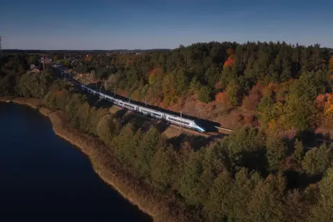 Pociąg Pendolino mknie przez jesienne krajobrazy nad jeziorem, w stronę Nidzicy, a potem dalej do Zakopanego.