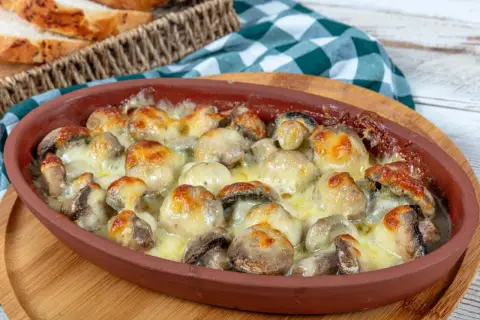 Pyszne pieczarki z piekarnika, zapieczone pod ciągnącym się serem, kuszą aromatem. Idealne na przekąskę lub dodatek do obiadu.