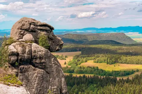 Majestatyczne, bledne skały górują nad zieloną doliną pełną lasów i pól. Widok zapiera dech w piersiach.