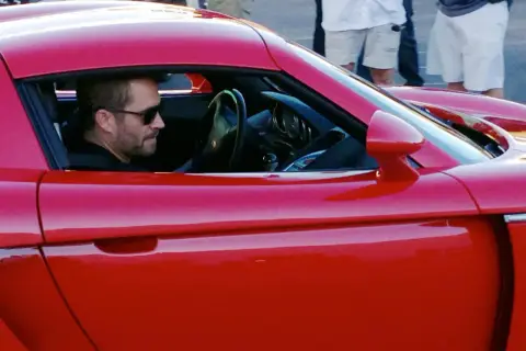 Paul Walker w czerwonym aucie. Jego paul walker data i miejsce śmierci to 30 listopada 2013, Santa Clarita.