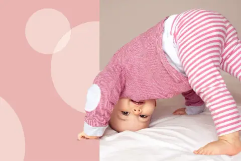 Uśmiechnięte dziecko w różowo-białe paski, kiedy dziecko raczkuje, wywraca się do góry nogami na białym tle.