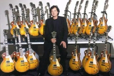 Jimmy Page, entouré de sa collection de guitares, dont une guitare iconique de Jimmy Page.