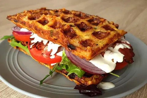 Pyszne keto gofry z mascarpone, pomidorem, czerwoną cebulą i chrupiącym boczkiem. Idealna przekąska.