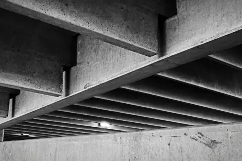 Skomplikowana konstrukcja z betonu, z widocznymi belkami i żebrowaniem. Ta klasa betonu tworzy surowy, architektoniczny krajobraz.