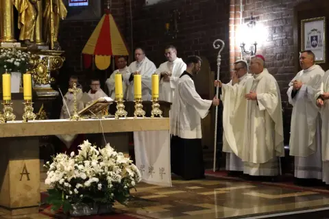 Uroczystość 3 października w kościele. Księża w białych szatach stoją przy ołtarzu, obok chłopcy ministranci.