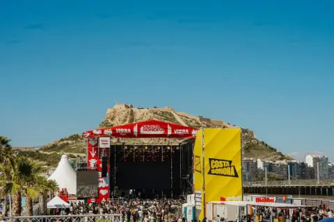 Gran concierto en la costa Sonora, con un escenario imponente y una multitud disfrutando bajo el sol.