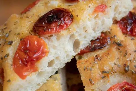 Puszysta focaccia z pomidorkami koktajlowymi i ziołami. Idealna na oryginalna włoska focaccia przepis.