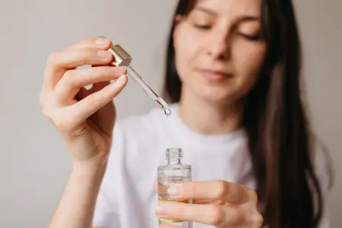 Kobieta aplikuje serum z niacynamidem, oczekując widocznych efektów poprawy kondycji skóry.