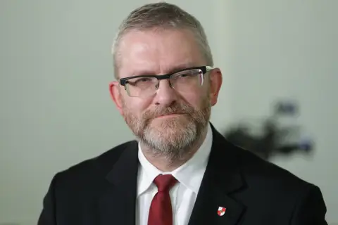 Grzegorz Braun w garniturze i krawacie, z okularami i brodą. Czy zostanie wykluczony z klubu za kontrowersyjne wypowiedzi o Izraelu?