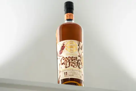 Butelka whisky "Cocoa Drift" z etykietą przedstawiającą wiśnie i czekoladę.