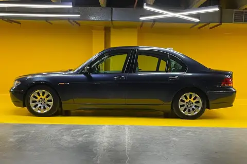 Eleganckie bmw e67 w ciemnym kolorze, zaparkowane na tle jaskrawożółtej ściany.